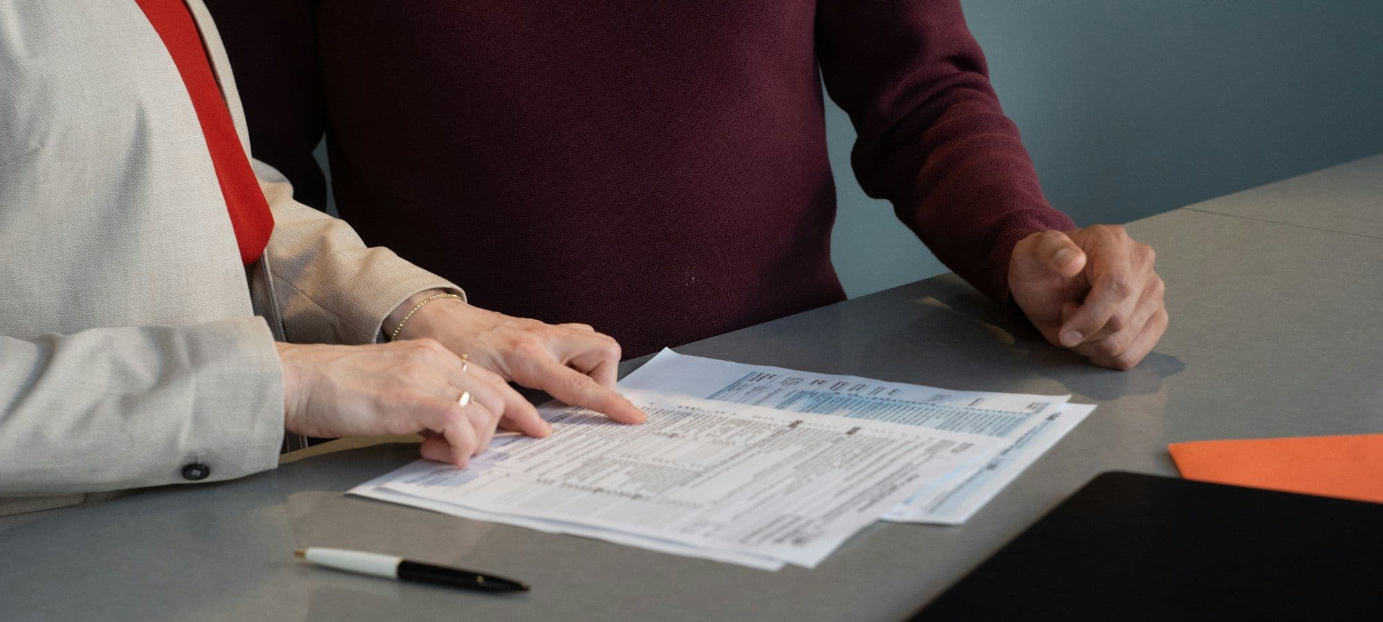 Two people reviewing an offering document at a table