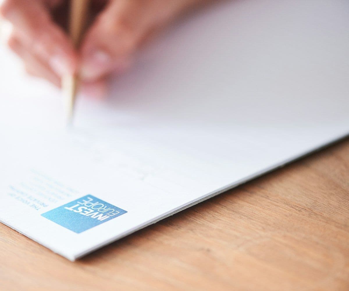 A hand writing notes on paper